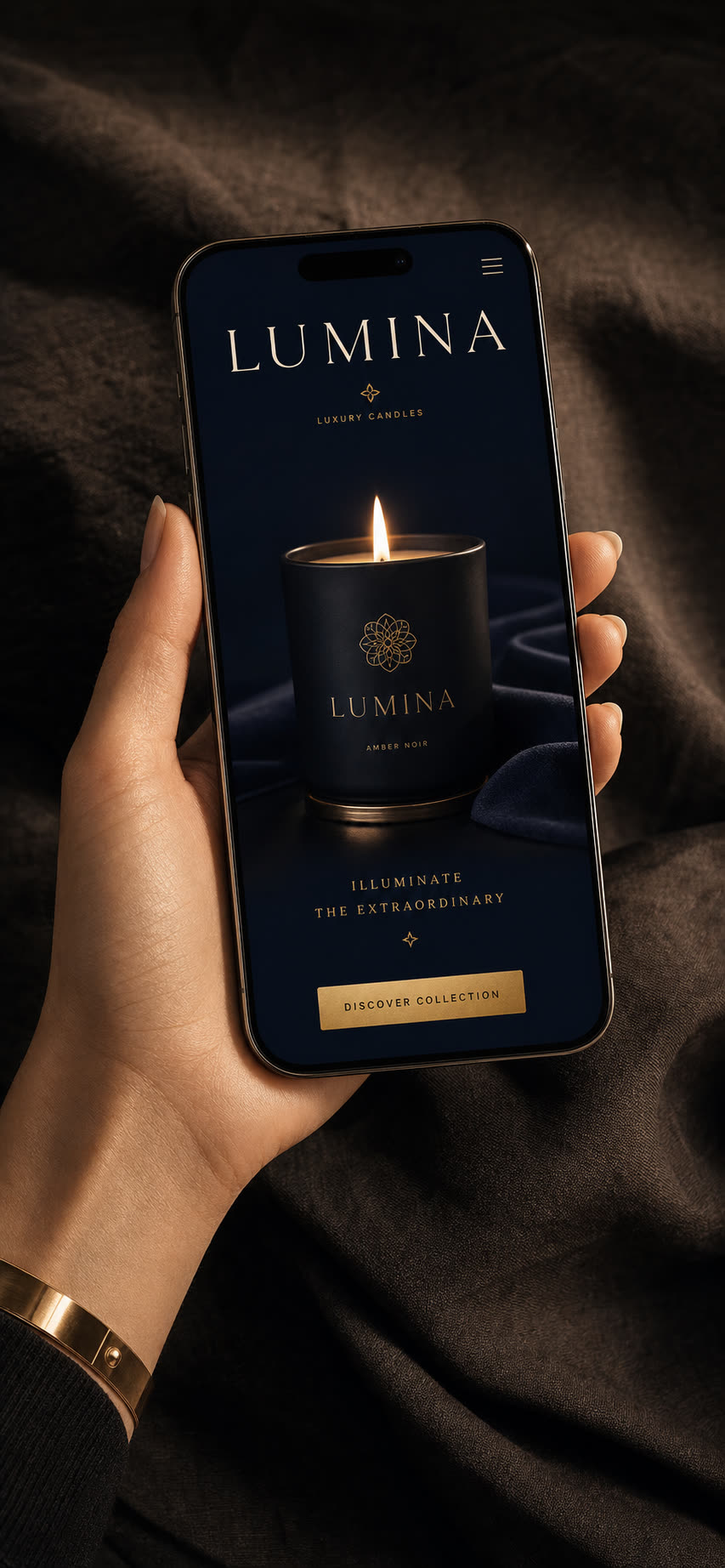 Sklep mobilny Lumina w dłoni: granatowe tło, kremowa typografia serif, świeca z monogramem, złoty przycisk DISCOVER COLLECTION